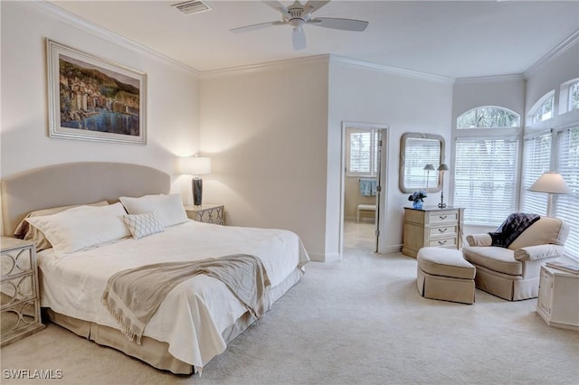 carpeted bedroom with a ceiling fan, visible vents, baseboards, ornamental molding, and ensuite bath