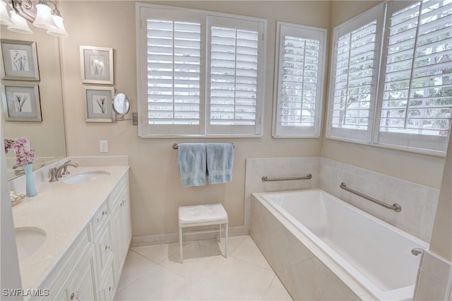 bathroom with a garden tub, tile patterned flooring, a sink, baseboards, and double vanity