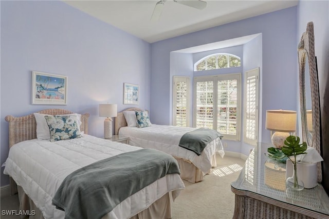 carpeted bedroom featuring a ceiling fan, multiple windows, and baseboards