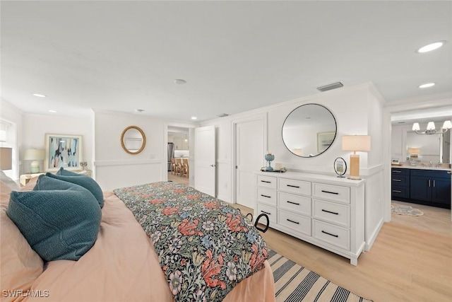 bedroom with light wood finished floors, visible vents, connected bathroom, and recessed lighting