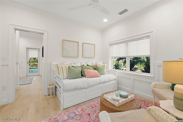 bedroom with ornamental molding, multiple windows, visible vents, and a decorative wall