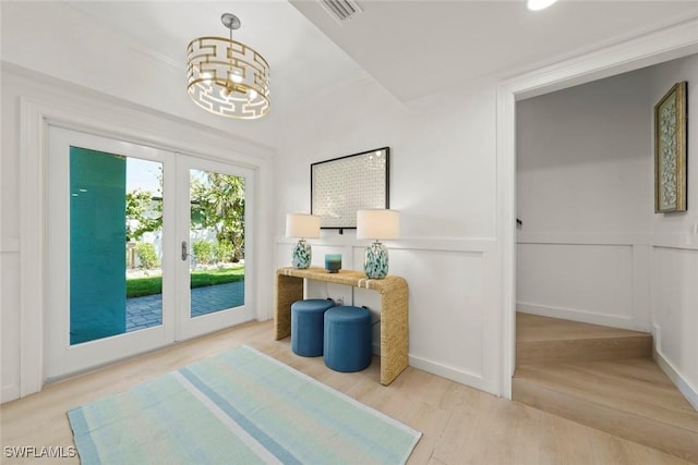 entryway with an inviting chandelier, visible vents, wood finished floors, and french doors