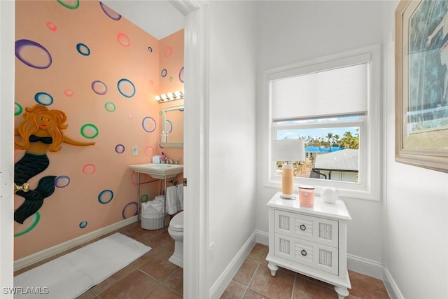 bathroom with toilet, baseboards, and tile patterned floors