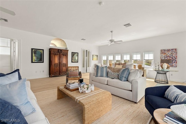 living room featuring visible vents, ceiling fan, and light wood-style flooring