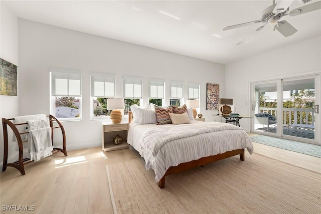 bedroom featuring light wood-type flooring, access to exterior, ceiling fan, and multiple windows