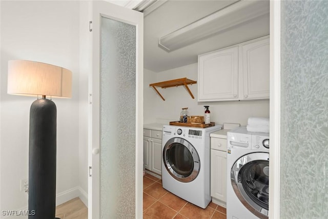 laundry area featuring cabinet space, washer and clothes dryer, and light tile patterned flooring