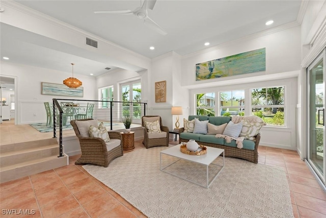 living area with plenty of natural light, visible vents, crown molding, and light tile patterned floors