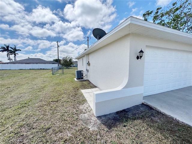 view of side of home with a yard, fence, central AC unit, and stucco siding