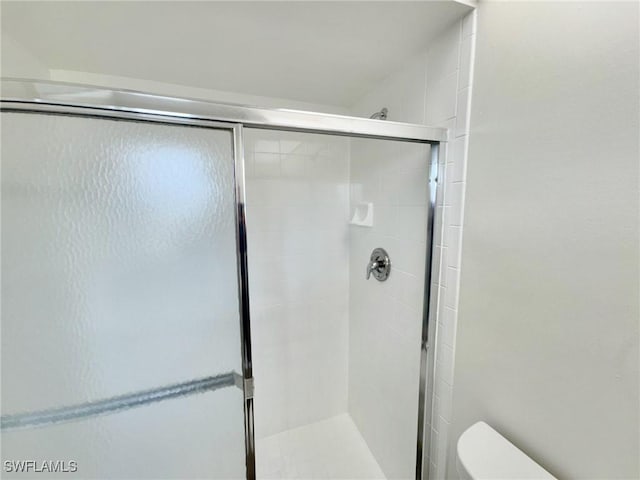 full bathroom with a shower stall and toilet