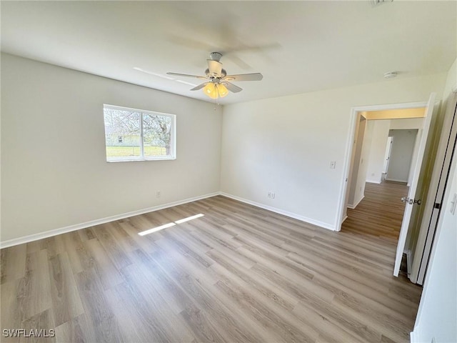 empty room featuring light wood-style flooring, baseboards, and ceiling fan