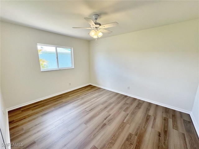 empty room featuring ceiling fan, wood finished floors, and baseboards