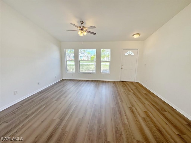 unfurnished living room featuring ceiling fan, baseboards, and wood finished floors