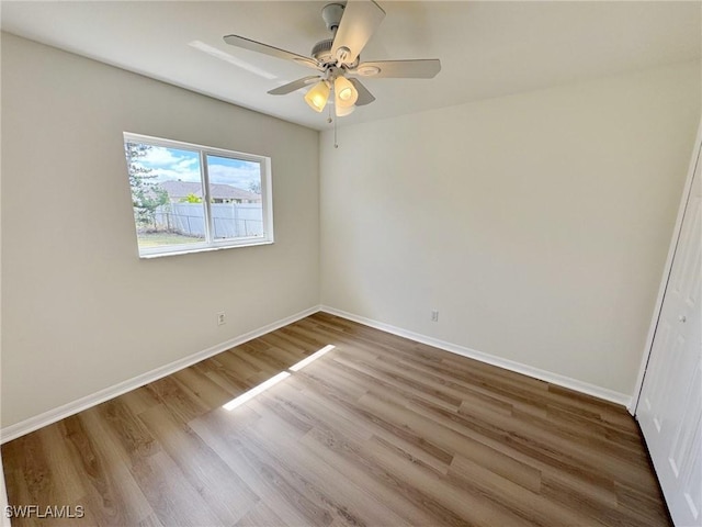 unfurnished bedroom featuring wood finished floors, a ceiling fan, and baseboards