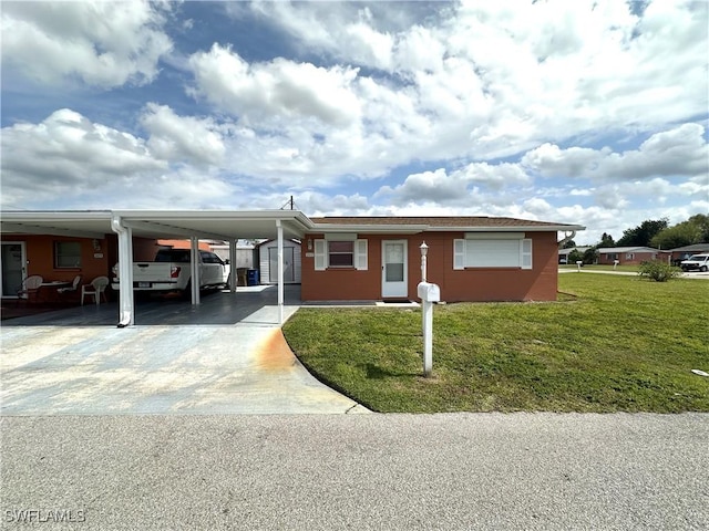 view of front of property with a front lawn, an attached carport, and concrete driveway