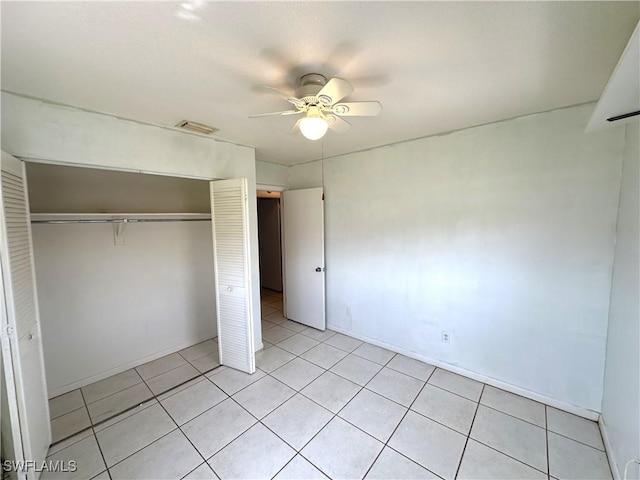 unfurnished bedroom featuring light tile patterned floors, ceiling fan, a closet, and visible vents