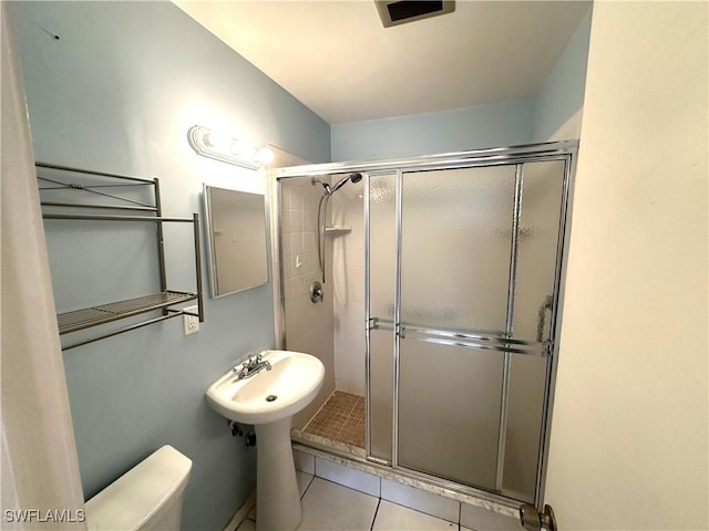 full bathroom featuring toilet, a shower stall, visible vents, and tile patterned floors