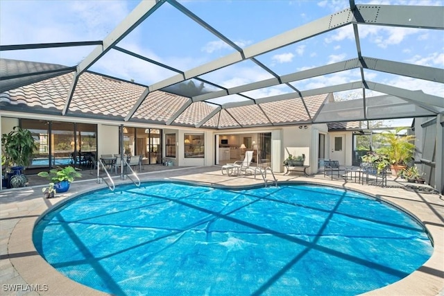 pool featuring glass enclosure and a patio area