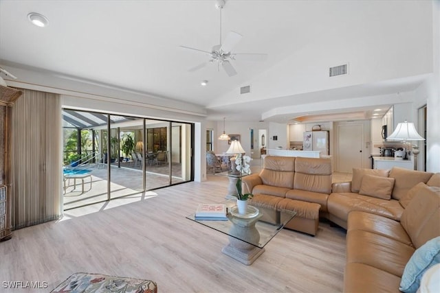 living room with high vaulted ceiling, light wood-style flooring, visible vents, and ceiling fan