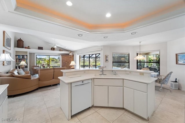 kitchen featuring a raised ceiling, light countertops, and dishwasher