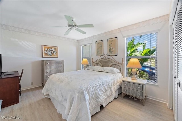 bedroom with light wood-type flooring, ceiling fan, and baseboards