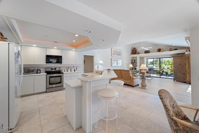 kitchen with electric range, a raised ceiling, open floor plan, fridge with ice dispenser, and black microwave