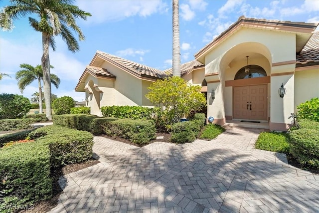 exterior space featuring a tiled roof and stucco siding