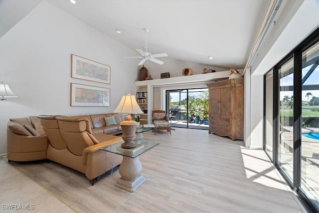 living area featuring light wood-style floors, high vaulted ceiling, and a ceiling fan