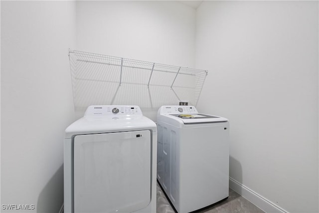 laundry room featuring laundry area, washing machine and dryer, and baseboards