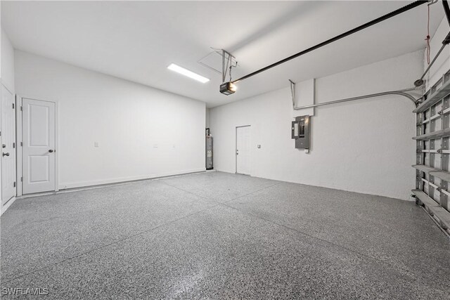 garage featuring water heater, electric panel, and a garage door opener