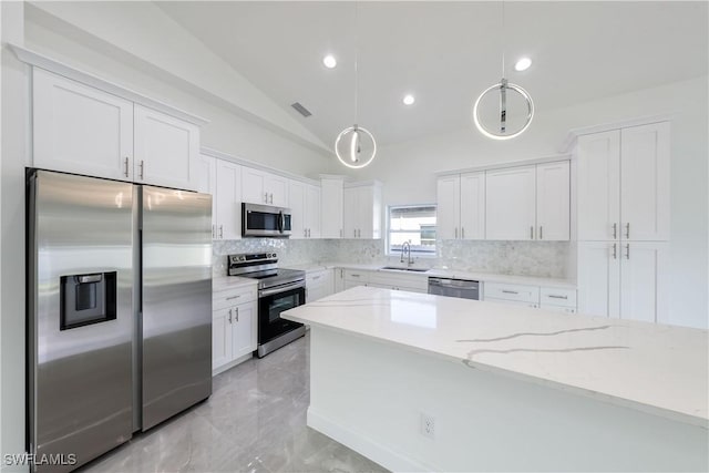 kitchen with stainless steel appliances, a sink, white cabinets, and decorative backsplash