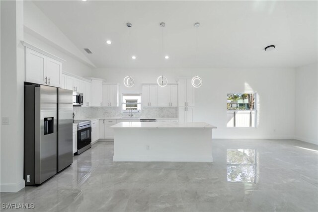 kitchen with a center island, stainless steel appliances, light countertops, backsplash, and white cabinetry