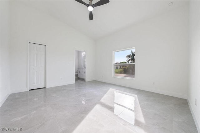 unfurnished bedroom featuring high vaulted ceiling, ensuite bath, a ceiling fan, and baseboards