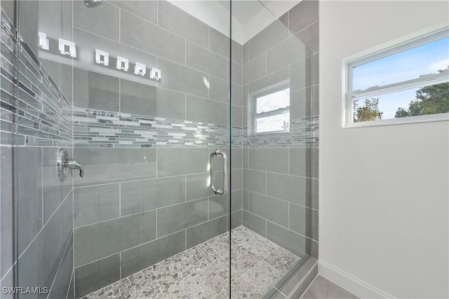 full bath featuring a stall shower and baseboards