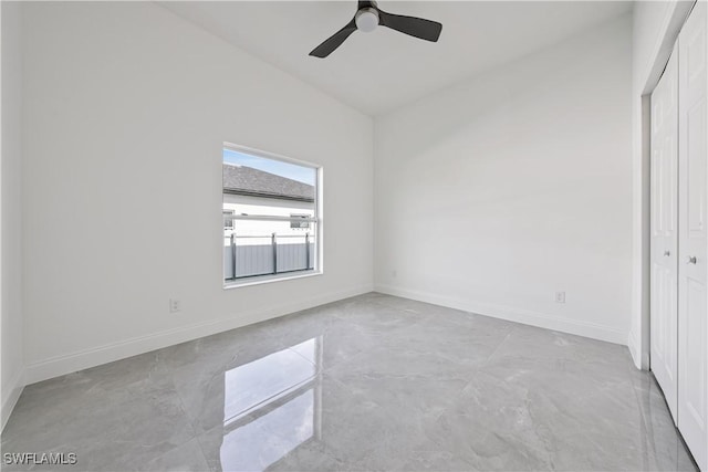 unfurnished bedroom featuring ceiling fan, a closet, and baseboards