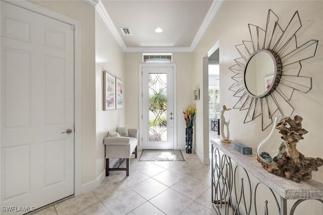 entryway featuring baseboards, light tile patterned floors, and crown molding