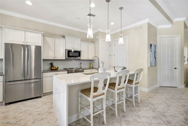 kitchen with appliances with stainless steel finishes, visible vents, a sink, and light tile patterned floors