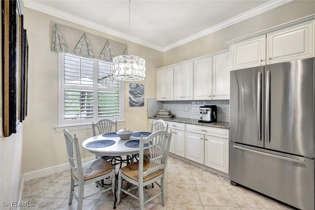 kitchen featuring freestanding refrigerator, crown molding, decorative backsplash, and light tile patterned floors