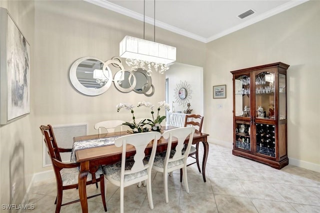 dining room featuring visible vents, crown molding, baseboards, and light tile patterned floors