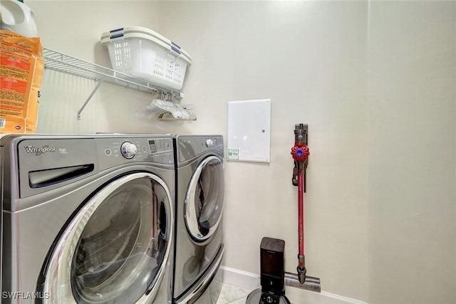 washroom featuring laundry area, washer and clothes dryer, baseboards, and tile patterned floors