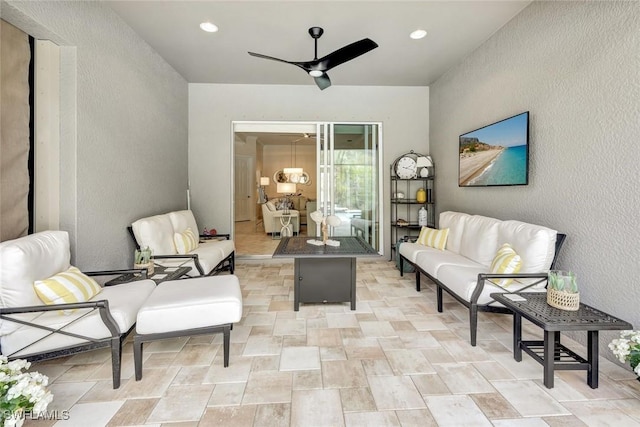 living area with a ceiling fan, recessed lighting, and a textured wall