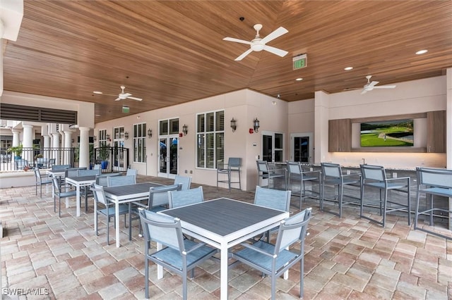 view of patio featuring french doors, outdoor dry bar, a ceiling fan, and outdoor dining space