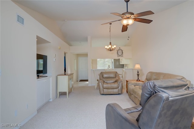 living area featuring visible vents, light carpet, lofted ceiling, and ceiling fan with notable chandelier