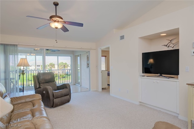 living area featuring a ceiling fan, baseboards, visible vents, lofted ceiling, and light colored carpet