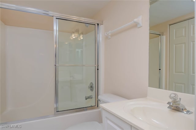 full bath with vanity, toilet, and combined bath / shower with glass door