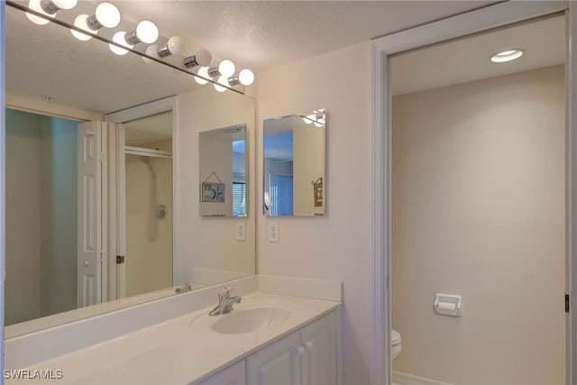 full bathroom with a shower with door, toilet, and vanity