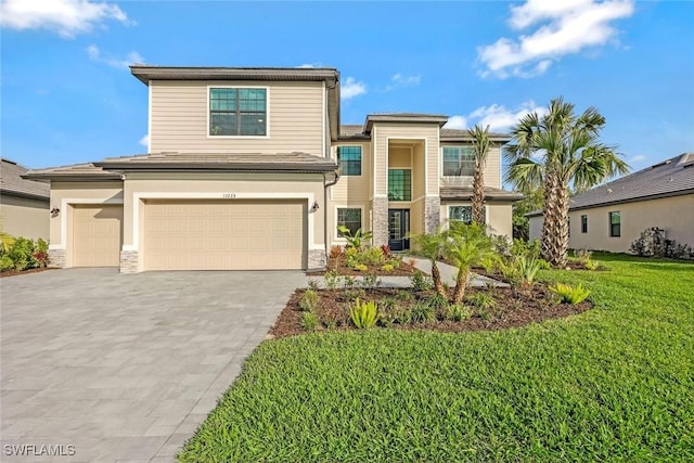 view of front facade featuring driveway, stone siding, a garage, and a front yard