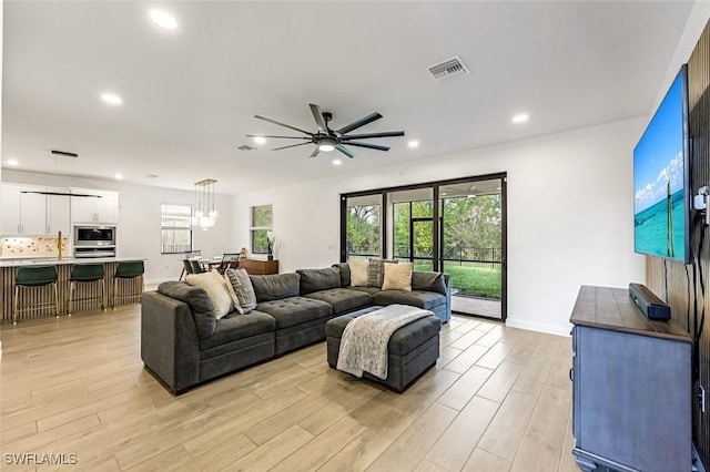 living area featuring light wood finished floors, visible vents, a wealth of natural light, and recessed lighting