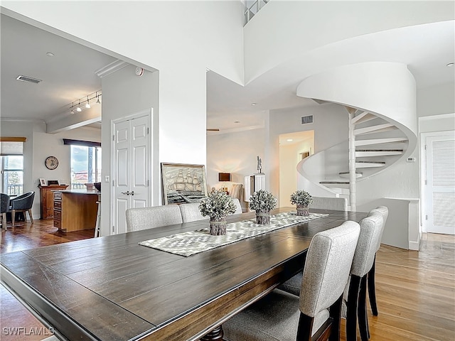 dining room with stairs, rail lighting, visible vents, and light wood-style floors