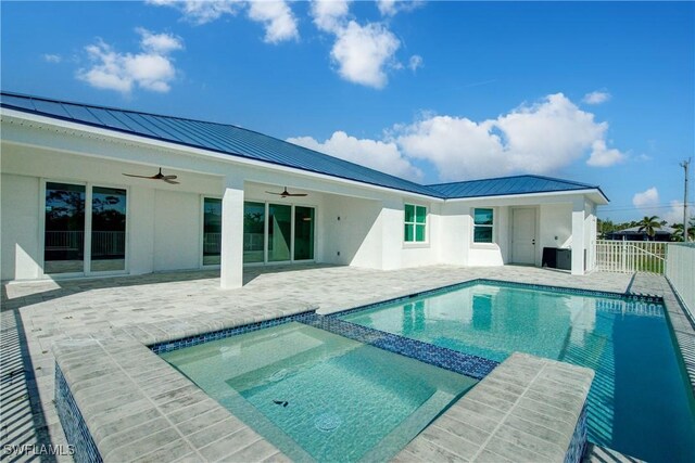 view of swimming pool with a pool with connected hot tub, fence, a patio, and ceiling fan