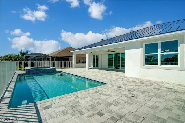 view of pool featuring a pool with connected hot tub, fence, a ceiling fan, and a patio